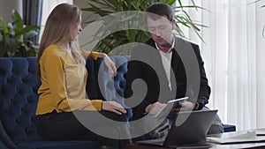 Cheerful Caucasian coworkers giving high five to each other. Portrait of young brunette man and woman creating business