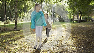 Cheerful caucasian family playing soap bubbles in the sunny autumn park. Smiling grandmother and granddaughter having