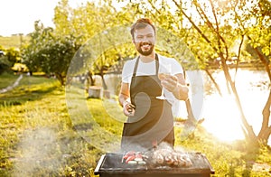 Cheerful chef offering wine during picnic