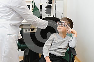 Cheerful child boy in glasses checks eye vision pediatric ophthalmologist