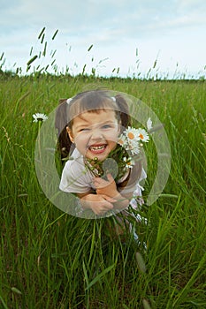 Cheerful child embraces wild flowers