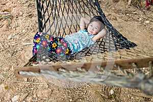 Cheerful child enjoying and relaxing in hammock, outdoor on summer day.