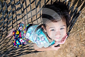 Cheerful child enjoying and relaxing in hammock, outdoor on summer day.
