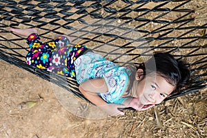 Cheerful child enjoying and relaxing in hammock, outdoor on summer day.