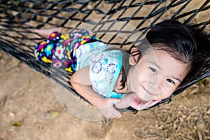 Cheerful child enjoying and relaxing in hammock, outdoor on summer day.