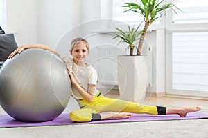 Cheerful Child with Fitness Ball on Yoga Mat