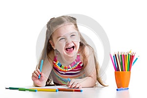 Cheerful child girl drawing with pencils in