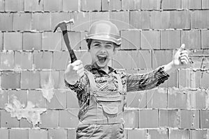 cheerful child laborer using building uniform and hammer tool, laborer