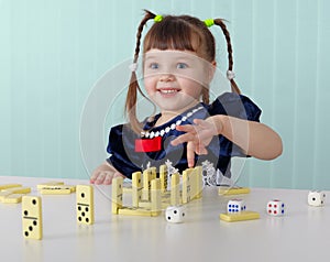 Cheerful child playing with small toys at table