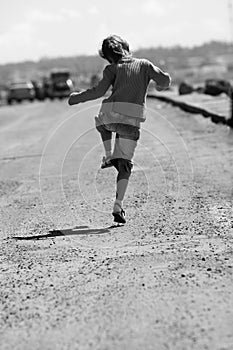 cheerful child skipping along the road photo