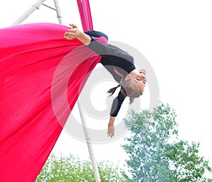 Cheerful child training on aerial silks