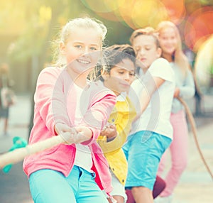 Cheerful children are competing and tug of war