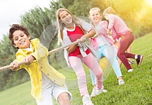 Cheerful children are competing and tug of war