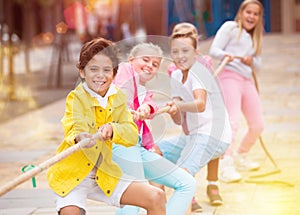 Cheerful children are competing and tug of war