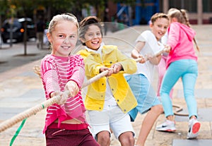 Cheerful children are competing and tug of war