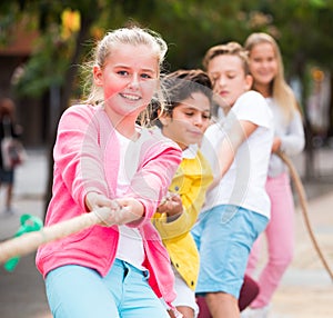 Cheerful children are competing and tug of war