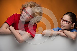 Cheerful children in glasses looking away whil