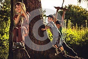 Cheerful children having fun outdoors in forest during summer holidays in countryside symbolizing happy carefree childhood