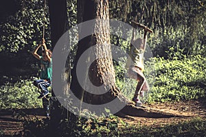 Cheerful children having fun outdoors woods during summer holidays in countryside symbolizing happy carefree childhood