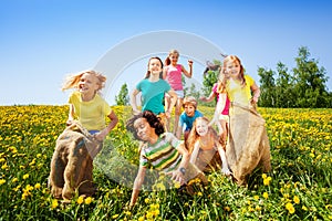 Cheerful children jumping in sacks play together