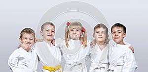 Cheerful children in karategi on a gray background