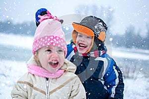 Cheerful children playing together on snowy winter day.