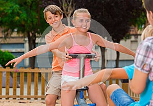 Cheerful children are teetering on the swing photo