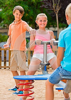 Cheerful children are teetering on the swing photo