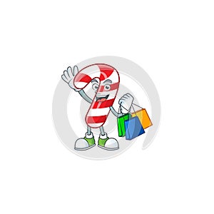 Cheerful christmas candy cane cartoon character waving and holding Shopping bags