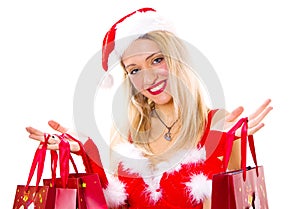 Cheerful christmas woman in santa`s wear smiling and holding shopping bags