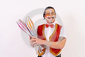 Cheerful circus performer skillfully juggling a number of clubs isolated on white background