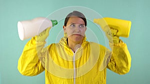 Cheerful cleaning lady in a yellow suit on a blue background. The concept of professional house cleaning. The cleaner