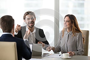 Cheerful colleagues laughing at joke at meeting having funny conversation
