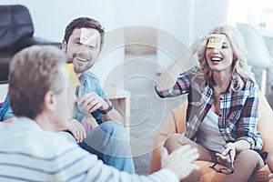 Cheerful colleagues playing game with stickers on the foreheads