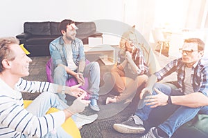 Cheerful colleagues sitting in circle during the break