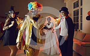 Cheerful confident young man in spooky clown costume having fun at Halloween party.