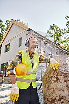 cheerful cottage builder in safety gloves