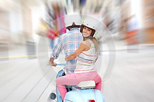 Cheerful coupl riding blue retro scooter