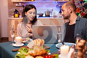 Cheerful couple buying xmas gift present paying online with credit card