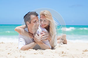 Cheerful couple embracing and lying on the beach o