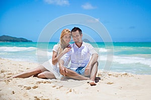 Cheerful couple embracing and posing on the beach