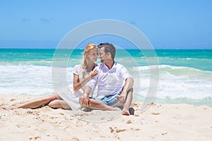 Cheerful couple embracing and posing on the beach