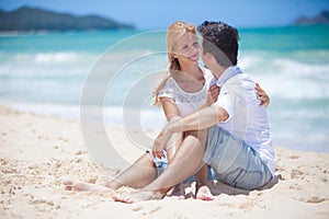 Cheerful couple embracing and posing on the beach