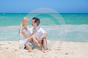 Cheerful couple embracing and posing on the beach
