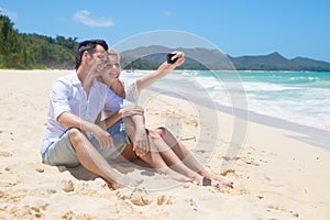 Cheerful couple embracing and posing on the beach