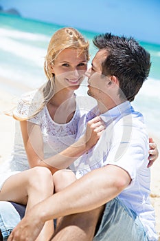 Cheerful couple embracing and posing on the beach