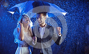 Cheerful couple enjoying the summer rain