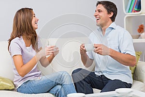 Cheerful couple enjoying their tea at home