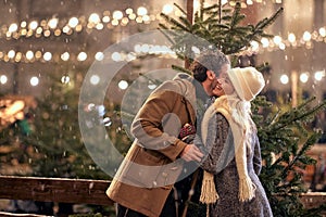 Cheerful couple enjoying the winter night; Festive concept