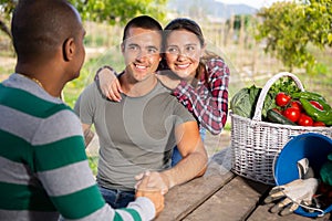 Cheerful couple of gardeners talking to neighbor outdoors